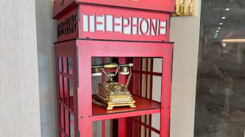 Una cabina telefónica roja con un emblema de corona y la palabra 'TELEPHONE' escrita en ella.
