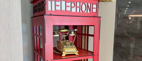 A red telephone booth with a crown emblem and the word 'TELEPHONE' on it.