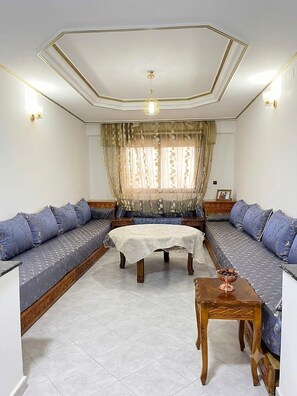 A room with a sofa set, a small table, and a decorative ceiling. -  2-bedroom apartment in vibrant Tanger for your stay (Tanger)
