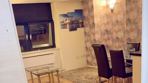 A dining area with a glass table, dark chairs, and a patterned rug. - 2 Spacious Double Bedroom - Bradford City Center (Bradford)