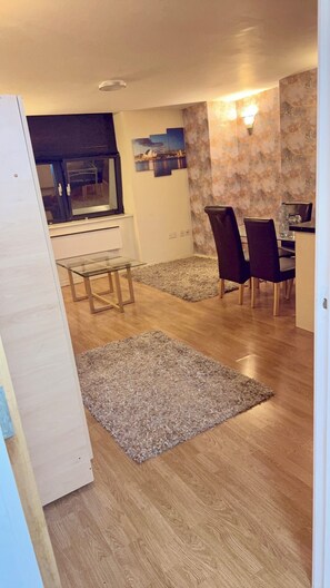 A dining area with a glass table, dark chairs, and a patterned rug. - 2 Spacious Double Bedroom - Bradford City Center (Bradford)