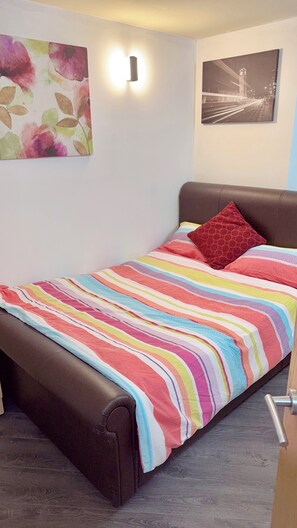 A single bed with a striped bedspread, a brown headboard, and a red pillow. - 2 Spacious Double Bedroom - Bradford City Center (Bradford)