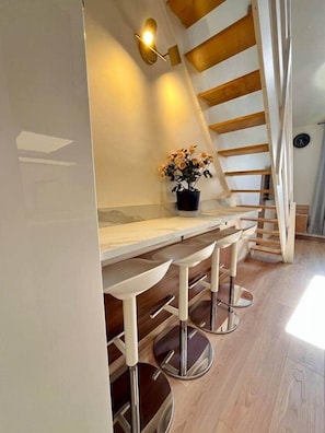 Una cocina con una escalera de madera, una encimera y una planta en maceta.