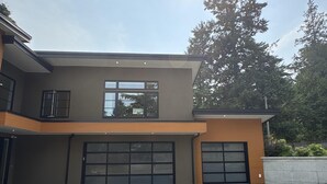 A modern two-story house with a large garage and a paved driveway. - Coastal Elegance and Oceanfront Luxury Estate (Central Saanich)