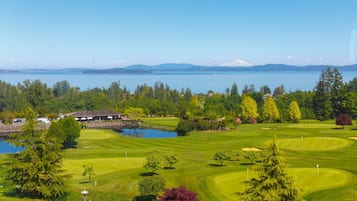 Golfkenttä, jossa on järvi, puita ja taustalla näkyvä rakennus.