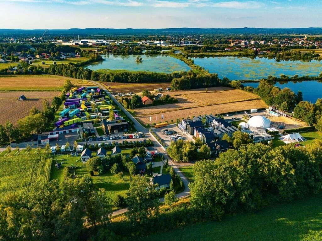 An aerial view of a campsite with RVs, tents, and a large white dome structure.