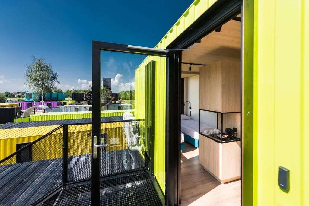 Ein modernes Interieur mit Balkon, einem Bett und einer kleinen Küchenzeile.