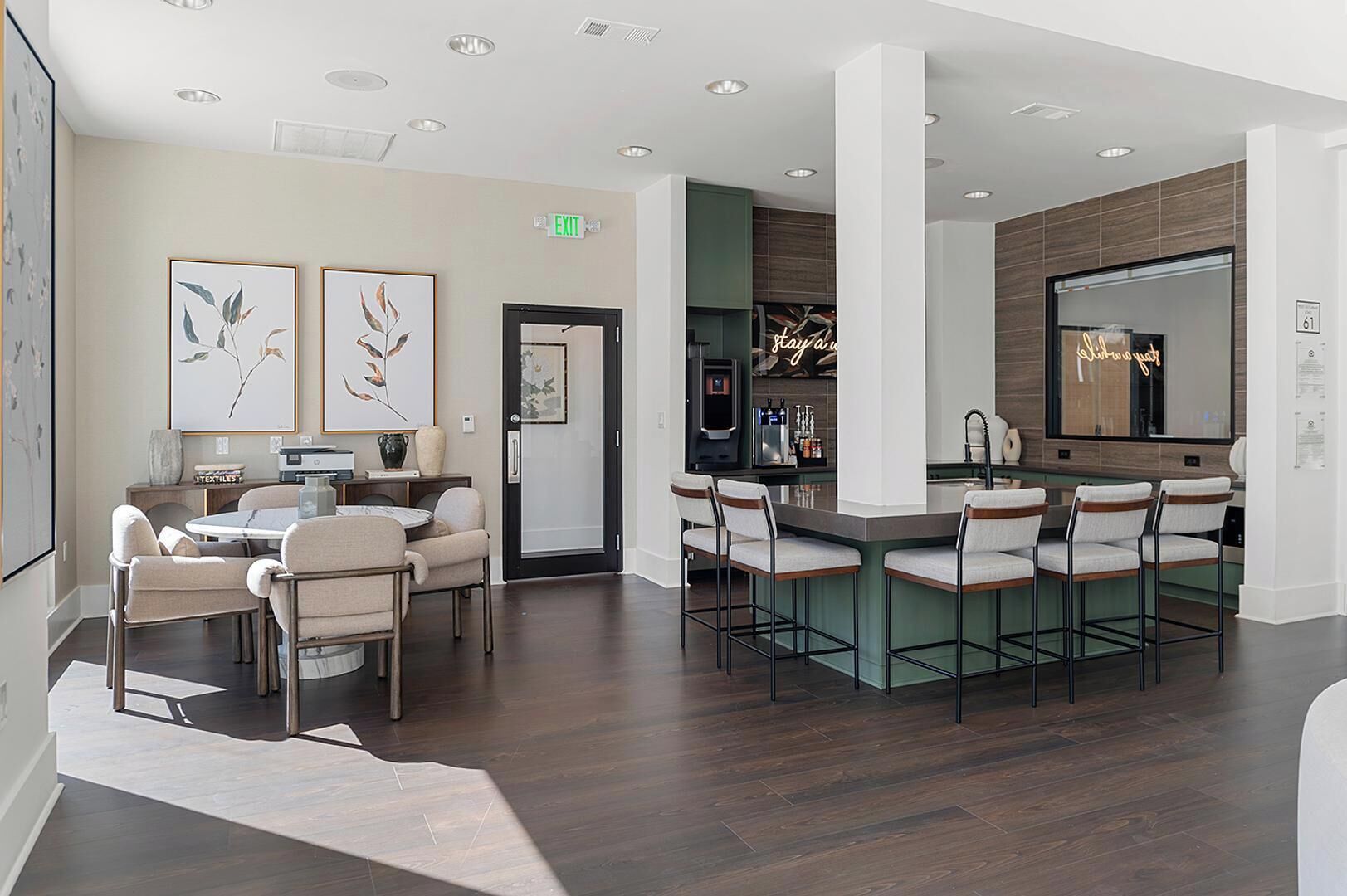 A modern hotel lobby with a bar area, seating, and artwork on the walls.