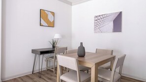 A dining area with a table, chairs, a vase, and two wall-mounted artworks. - Landing | Stylish 2BD, Yoga Studio, Clubhouse (Houston)