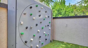 A climbing wall with various holds. - Landing | Modern 1BD, Clubhouse, Gym (Austin)