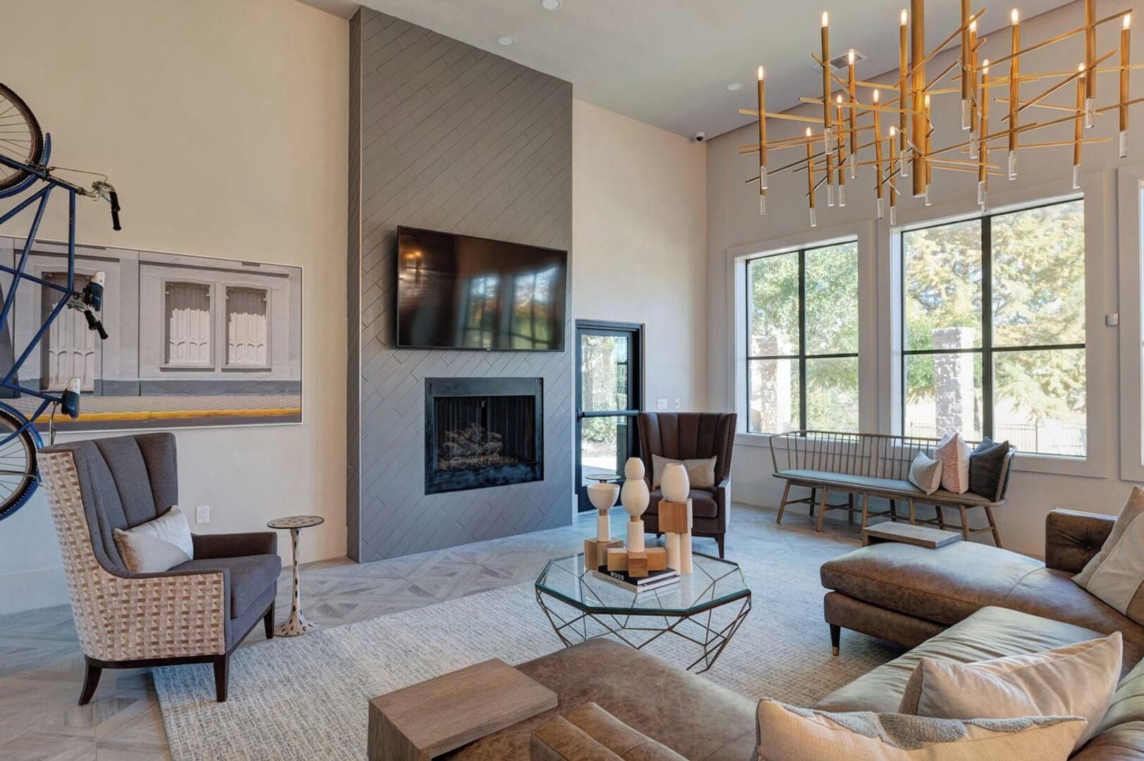 A modern living room with a fireplace, comfortable seating, and a large window.