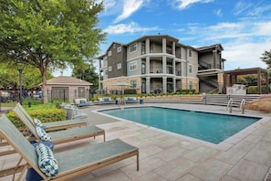 A residential building with a swimming pool, outdoor seating, and a covered area. - Landing | Modern 2BD, Clubhouse, Gym (Austin)