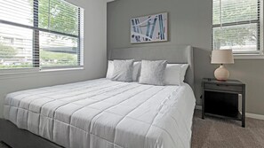 A bedroom with a bed, a nightstand, a lamp, and a painting on the wall. - Landing | Amazing 1BD, Clubhouse, Gym (Austin)