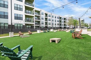 A residential building with multiple balconies, outdoor seating, and a well-maintained lawn. - Landing | Beautiful 2BD, Pool, Gym (Austin)