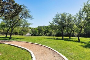 A park with a curved gravel path, green grass, and trees. - Landing | Spectacular 2BD, Pool, Gym (Austin)