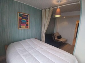 A bedroom with a bed, a curtain, a hanging light, and a wall-mounted picture. - 30m from ski slopes, Ground floor, tv, ski locker, 37m², Alpe d'Huez (L'Alpe d'Huez)