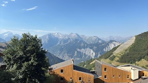 A mountain landscape with wooden buildings in the foreground. - 30m from ski slopes, Ground floor, tv, ski locker, 37m², Alpe d'Huez (L'Alpe d'Huez)
