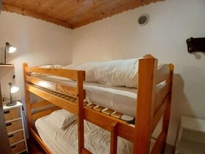A bunk bed with a desk and lamp, wooden ceiling, and white walls. - 20m from ski slopes, 1st floor, terrace, tv, ski locker, 70m², Alpe d'Huez (L'Alpe d'Huez)