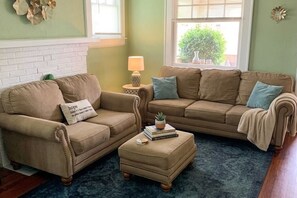 A living room with two sofas, a coffee table, and a lamp. - Cozy 2-bedroom bungalow with AC in charming Jacksonville (Jacksonville)