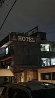 Um edifício com uma placa que diz 'HOTEL' e 'ROYAL OFFICE', indicando um hotel e possivelmente um escritório comercial.