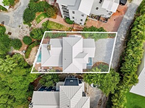 Ein modernes Gebäude mit einem einzigartigen Dachdesign, umgeben von üppigem Grün und einem gepflasterten Weg.