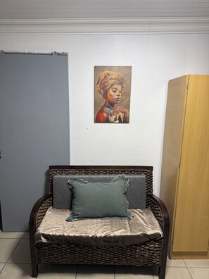 Una habitación con una cama, una puerta y un cuadro en la pared.