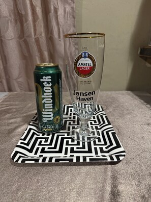 Una lata de cerveza Jansen Haven y un vaso sobre un mantel estampado.