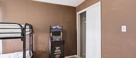 A room with a bunk bed, a door, and a gaming console.