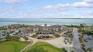 A large, two-story building with a symmetrical facade, a covered front porch, and a parking lot with multiple cars. - Anchor Down - 2 Bed | Beach, Fun, Dining, Golf (Seabrook Island)