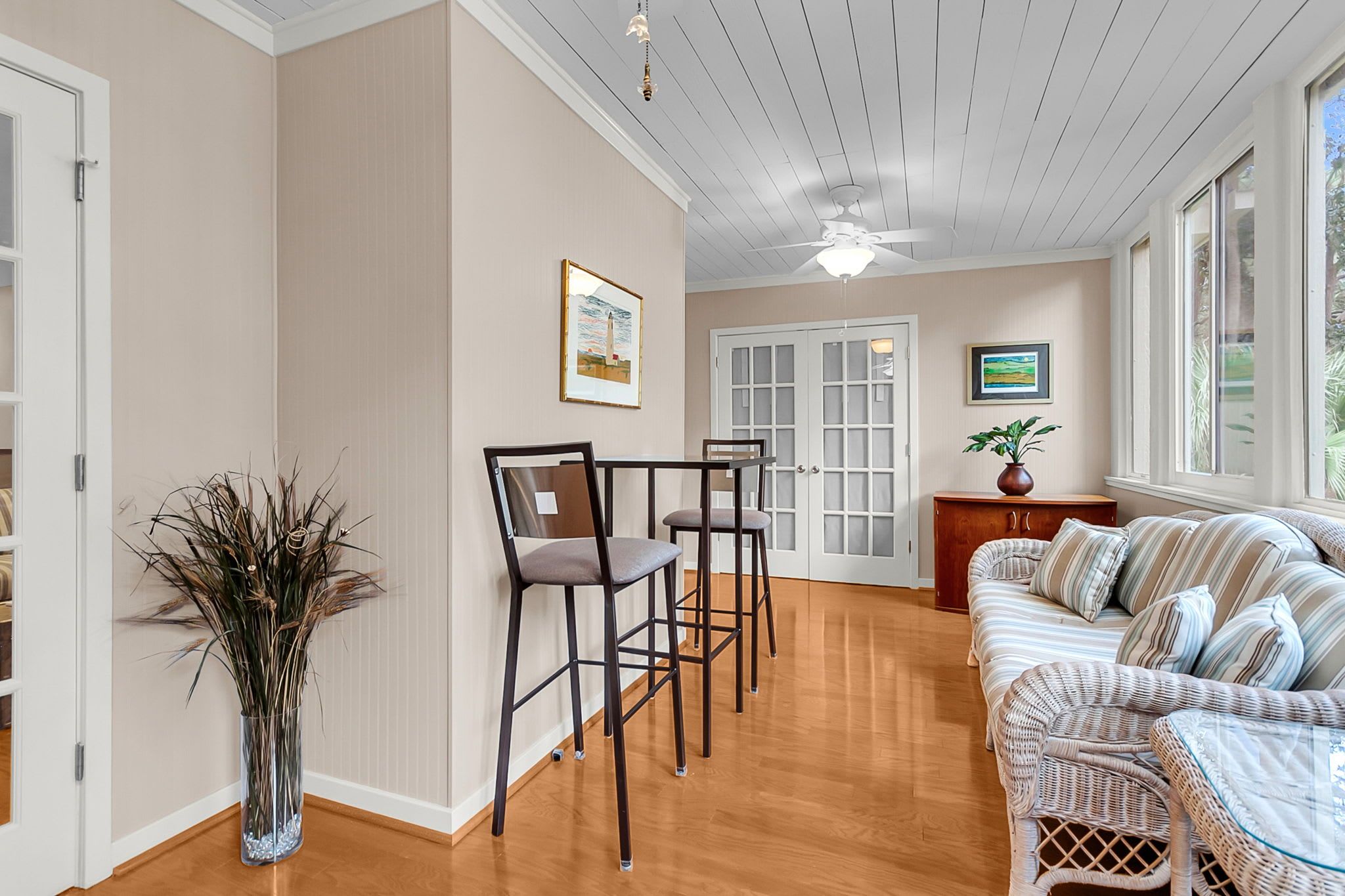 A spacious room with a dining area, a sofa set, and a ceiling fan.