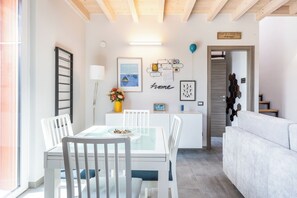 A modern living space with a dining area, a sofa, and a kitchen counter. - [Free Wi-Fi and parking] House between Como, Milan, and Lugano (Veniano)