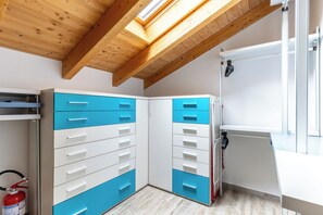A compact room with a sloped ceiling, wooden beams, a skylight, and a white radiator. - [Free Wi-Fi and parking] House between Como, Milan, and Lugano (Veniano)