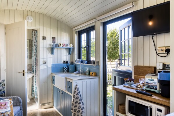 A kitchen with a window, a microwave, and a sink.