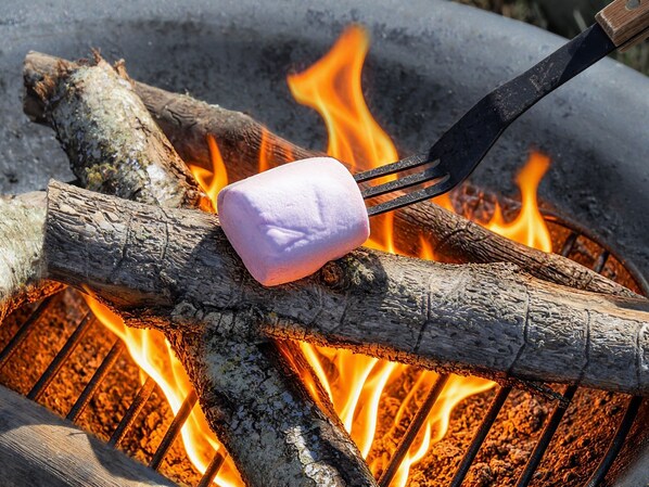 A marshmallow being roasted over a fire with a fork.