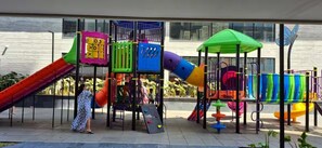 Ein Spielplatz mit verschiedenen Spielgeräten, darunter Rutschen und Kletterbereichen.