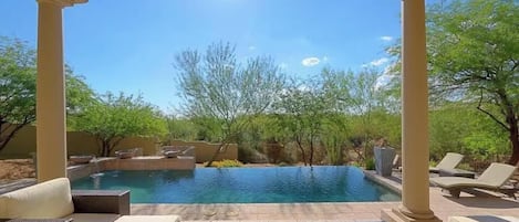 Un área de piscina con sillas de descanso y una pérgola.