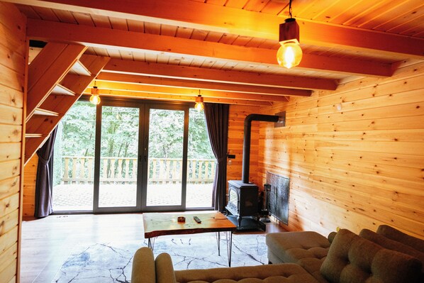 A cozy cabin interior with a fireplace, a table, and a sofa.