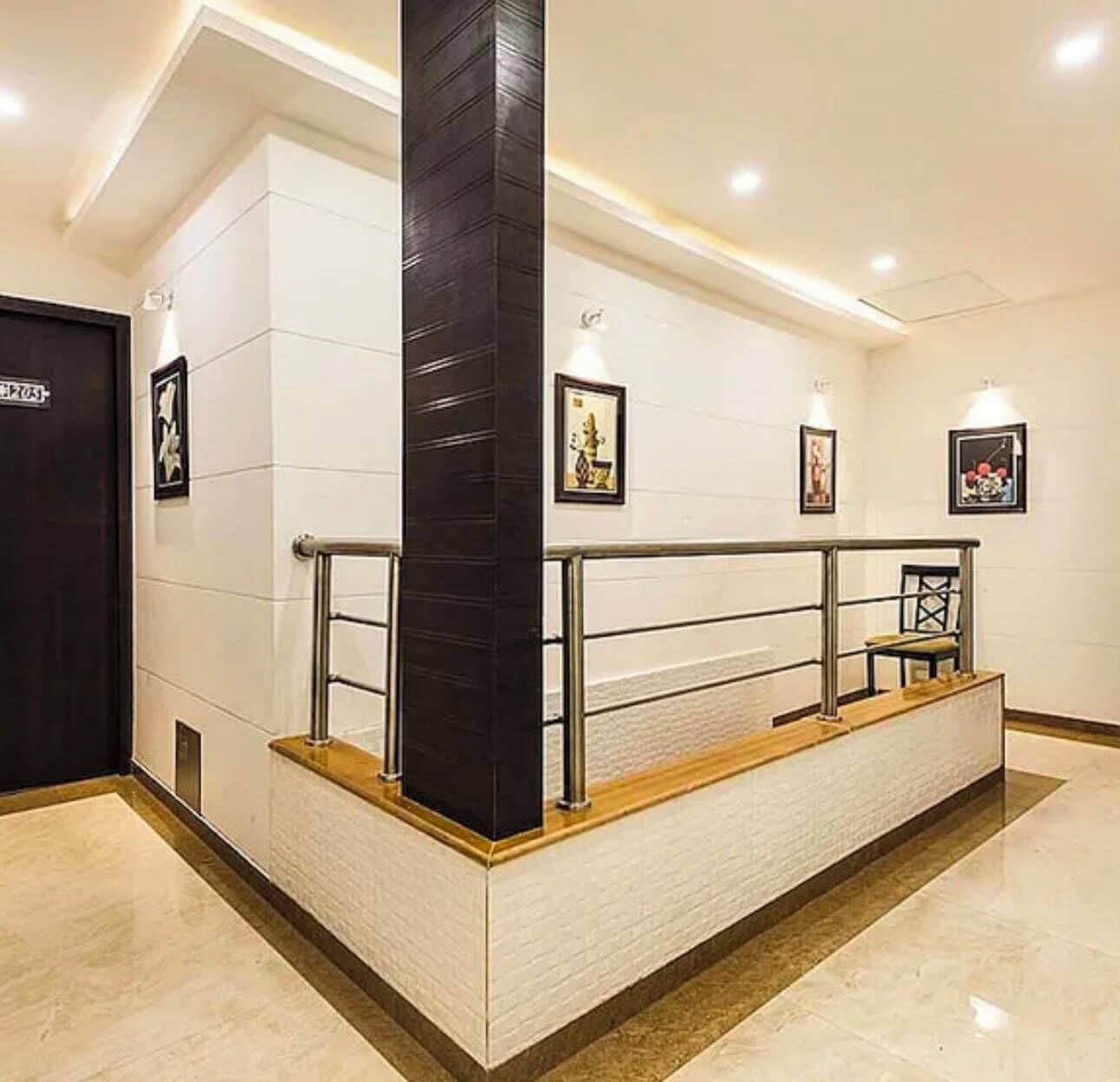 A reception area with a black pillar, a wooden counter, and framed pictures on the wall.