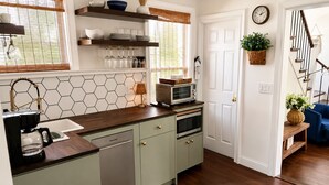 Una cocina con cafetera, microondas y armarios.
