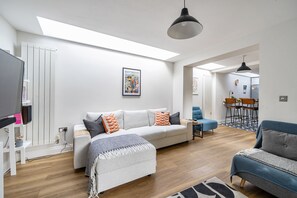 Una sala moderna con un sofá, sillones y un comedor.