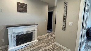 A hallway with a fireplace, a sign reading 'BAKERY,' and a door leading to another room. - Wonderful 4-bedroom Home Base in Phoenix- Freeway Access- Close to everything! (Phoenix)