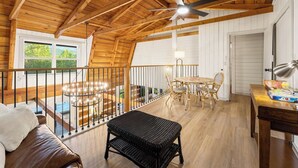 Un interno in legno con un tavolo da pranzo, sedie, una panca e una ventola a soffitto.