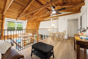Ein Holzinterieur mit Esstisch, Stühlen, einer Bank und einem Deckenventilator.