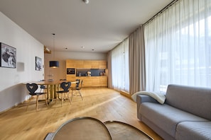 Ein modernes Wohnzimmer mit einem grauen Sofa, einem Holzesstisch und Stühlen.