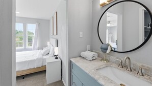 Quarto moderno com cama, mesa de cabeceira e um espelho grande.
