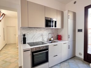 A modern kitchen with a built-in oven, a microwave, a sink, and a coffee machine. - Casa Nicolas 158 - Salento Explorer (Neviano)