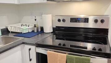 A kitchen with a microwave, oven, and a sink.