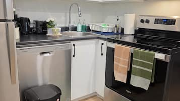 A modern kitchen with stainless steel appliances, a dishwasher, and a microwave.