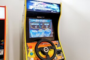 Eine Spieluhr für Videospiele mit Lenkrad und Knöpfen, die das Spiel 'The Fast and the Furious' zeigt.