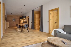 Ein modernes Interieur mit einer Holzeinrichtung, einem grauen Sofa und einer Fernbedienung auf einem kleinen Tisch.